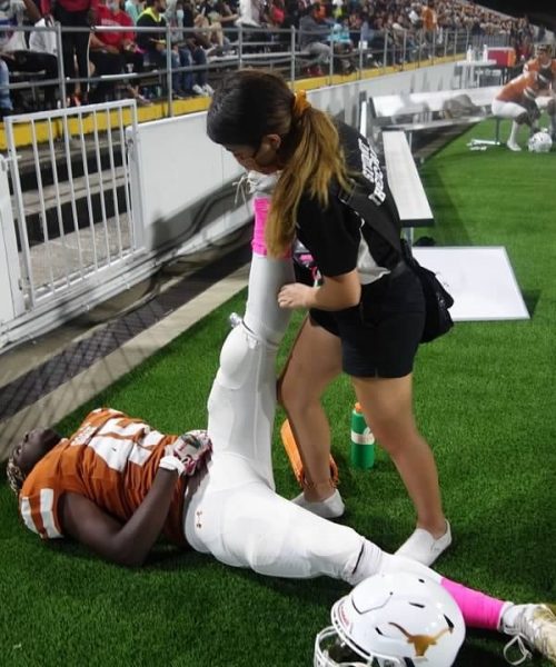 Dobie Student Athletic Trainer Aid helping stretch a player